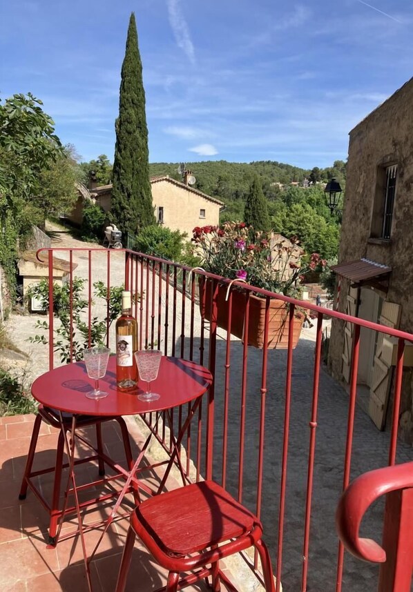 invitation à la détente sur le perron de la maison donnant sur une ruelle pavée calme et pittoresque