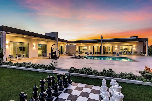 Unwind in this stunning backyard oasis with a private pool and life-size chess set.