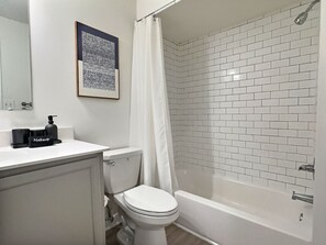 The pristine bathroom, complete with sleek fixtures and a relaxing tub, allows for refreshing morning routines or tranquil evening baths.