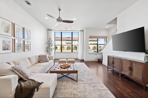 Living room: 65" Roku TV, sectional, swivel chairs (not pictured), baby gates