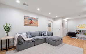 Our comfortable bright living room (3rd shared space) in the basement has a play area for kids and an arcade!