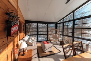 Our sunroom overlooks the lake and has comfortable seating and a dining table to play boardgames. 