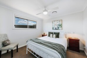 Relax in the fourth bedroom, complete with a queen bed, ducted air conditioning and earthy, inviting tones.