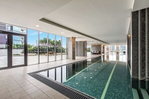 Dive into relaxation with this stunning indoor pool, featuring expansive views of the garden terrace through floor-to-ceiling windows.
