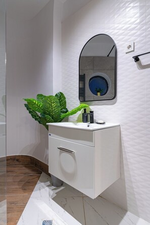 Bathroom equipped with mirros, sink, toilet, fluffy towels