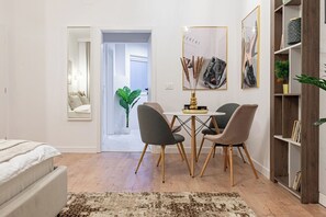 Dining table with chairs for enjoy a delicious dinner, library with books, cozy king size bed, wall paintings, mirros, stylish carpet
