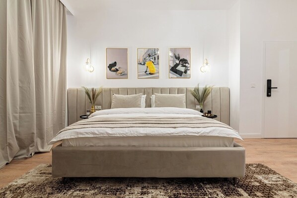 Cozy king size bed equipped with cotton linens, soft pillows, fluffy towels, bedside tables, socket near the bed, room darkening shades, internet, heating, wall paintings