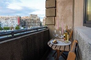 Small table and chair on the balcony that has a city view