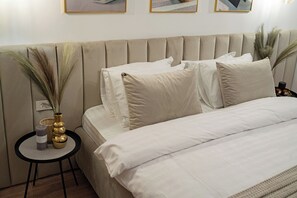 Cozy king size bed equipped with cotton linens, soft pillows, fluffy towels, bedside tables, socket near the bed, room darkening shades, internet, heating, wall paintings