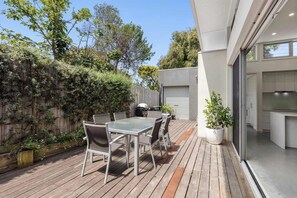 The private deck is perfect for outdoor dining and entertaining, with a BBQ and dining table 