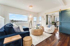 Cozy up in our living room, where expansive windows frame breathtaking waterfront views, creating the perfect ambiance for relaxation!