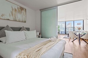 A bedroom with a queen sized bed & plush pillows.