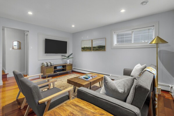 Modern living room with stylish decor, featuring a comfortable gray sofa, two matching armchairs, and a wooden coffee table. Perfect for relaxing or entertaining guests.