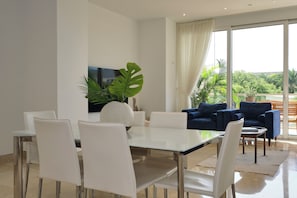 Enjoy meals in this stylish dining area, surrounded by natural light and views of lush greenery.