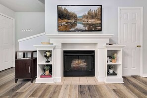  The living room features a large Smart TV, along with plush seating and a cozy gas fireplace.