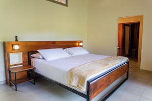 A peaceful bedroom with soft, neutral tones, plush bedding, and large windows letting in natural light, creating a calm atmosphere for rest.