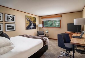 A bright and airy space featuring a restful bed, a dedicated workspace, and calming natural light