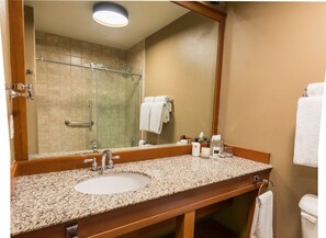 A bright and modern bathroom featuring a spacious vanity and walk-in shower, perfect for refreshing moments.