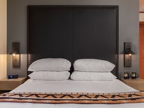 A cozy and stylish space with soft bedding and ambient lighting, inviting relaxation and comfort.