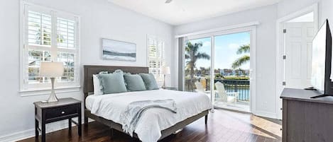 Wake up to serene views! Cozy king bed, and balcony access for a perfect morning.