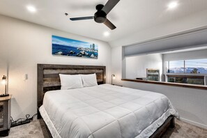 Bright and modern bedroom with a king-size bed and scenic window views.