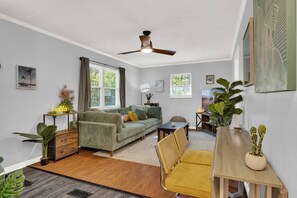 This large living room/dining room space features flexibilty for all! The couch and floor bolsters give a comfy spot for everyone to sit. The dining table opens and folds out making room for everyone to eat together. Don't need it? Fold it away!