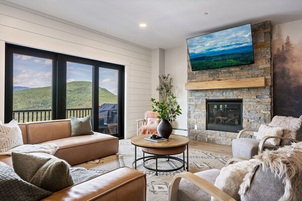 Bask in the natural light and breathtaking mountain views from the comfort of this cozy, modern living room—your perfect spot for relaxation.