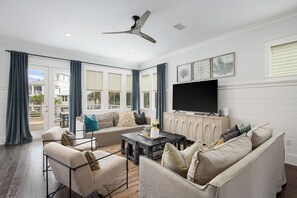 Light filled living room with plenty of seating, games & flat screen TV