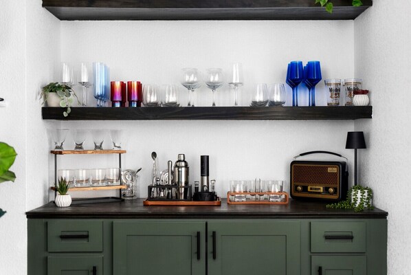 Elevate your stay with this stylish home bar, fully stocked with elegant glassware, cocktail essentials, and a cozy ambiance for the perfect evening unwind!