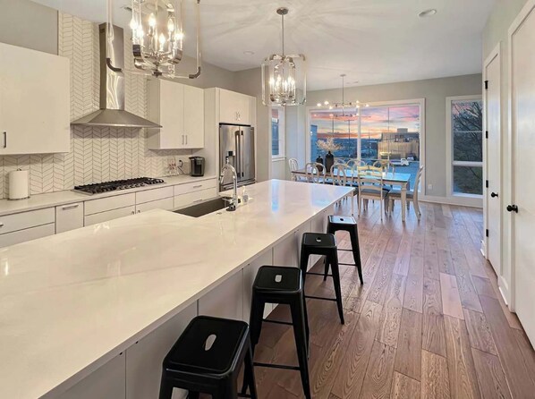 Kitchen: This open-concept kitchen and living area boasts a spacious island, contemporary pendant lights, and a seamless flow into the cozy living space.