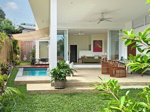 Ground floor: open living space with patio, pool, lush garden and family room