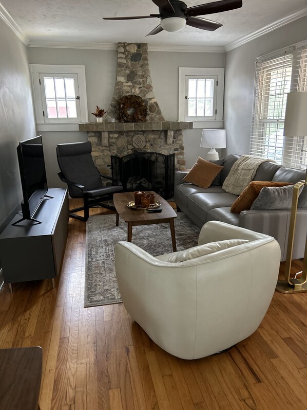 Living room features a stone fireplace, smart, and stylish furnishings.