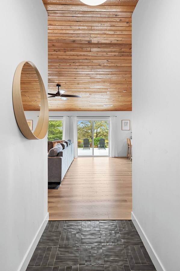 Step through a custom walnut door onto cool tile underfoot as the entry gently narrows—then opens into the light-filled living space. A quiet moment of calm before the house opens around you.
