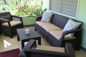 Relax on the verandah with comfortable seating and lush garden views