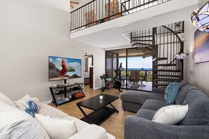 Living Area: Spacious and inviting with air conditioning, a ceiling fan, and a flat-screen TV.
