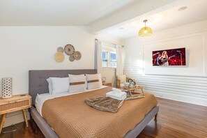 Primary bedroom with a smart TV, large walk-in closet, and en-suite bathroom.