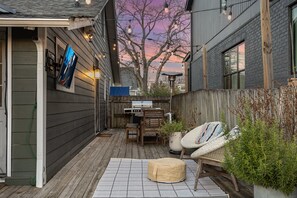Unwind on this cozy deck, complete with string lights, a grill, and plenty of seating for outdoor dining and relaxation.