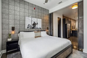 Brand new king size bed with luxurious linens, ceiling fan, nightstands, and Smart TV