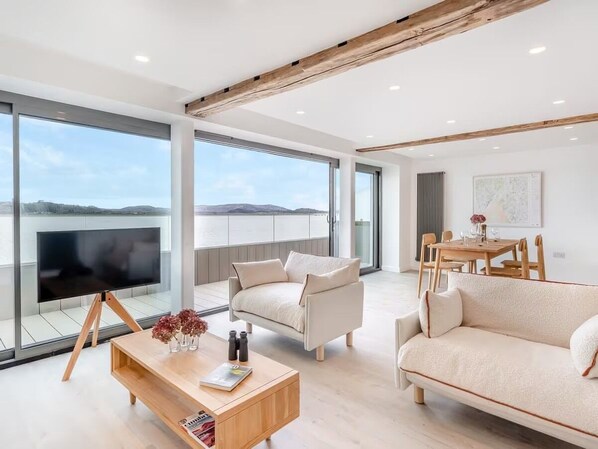 Open-space living area with large retractable doors to the balcony