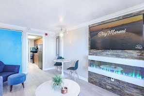 Modern comfort meets coastal charm in this inviting living space, featuring a smart TV, cozy fireplace, and a stylish dining nook. The perfect spot to relax after a beach day or enjoy a quiet night in with your favorite shows.