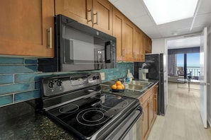 Cook with a view in this fully equipped kitchen featuring granite countertops, modern appliances, and a stylish backsplash. Whether it's breakfast or a beach day snack, everything you need is just steps from the ocean.