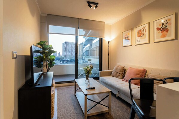 Relax in this cozy living room with city views, stylish decor, and a private balcony for a perfect urban retreat.