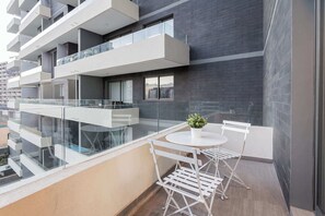 Charming private balcony with modern seating and city views, perfect for morning coffee or evening relaxation.