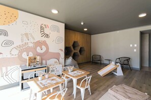 Delight your little ones in this charming playroom, complete with whimsical animal art and engaging play areas.