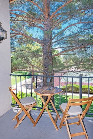 Shaded balcony with seating for four overlooking a park-like setting