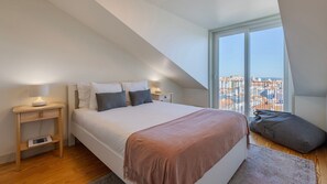 Wake to breathtaking city views from this serene, stylish bedroom with cozy linens. #CityView #PeacefulRetreat