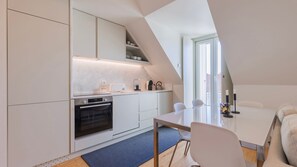 Enjoy meals in this modern, fully-equipped kitchenette and dining area, blending practicality with minimalistic charm. #CookInStyle #DinnerIn