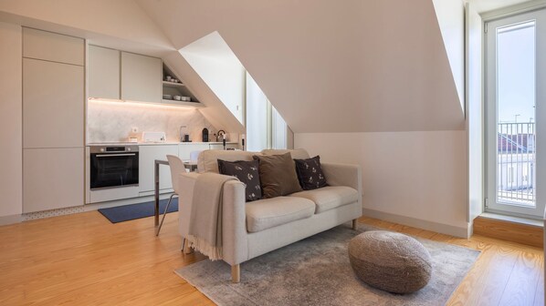 Relax in the elegant open-plan living space featuring a plush sofa, natural light, and contemporary design. #ModernComfort #RelaxAndUnwind #Lisbon