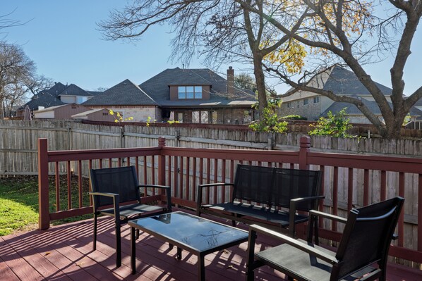Spacious deck in the backyard with outdoor seating for family and friends!