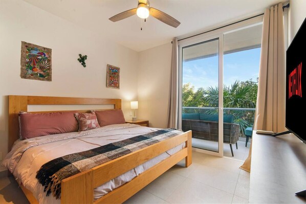 Unwind in the master bedroom with a king bed, AC, TV, and balcony.